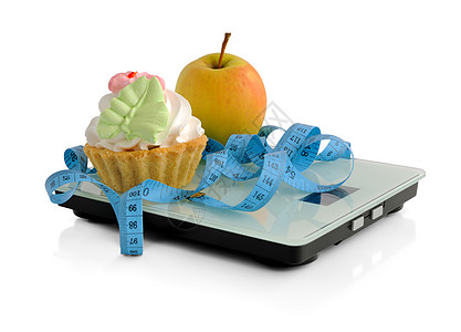 饼和苹果在比例尺测量胶带上包装奶油重量减肥身体餐厅篮子食物斗争蛋糕水果图片