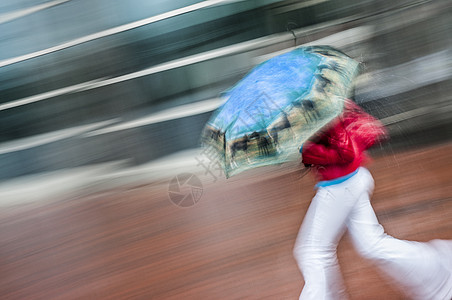 女性使用伞式雨伞运行图片