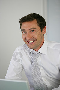 一个微笑的商务人士的肖像男人享受笔记本工作技术导演衬衫幸福工人领带图片