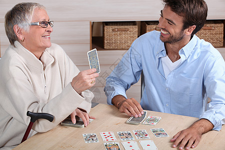 母亲和儿子打牌男性游戏白色女性微笑女士男人老年图片