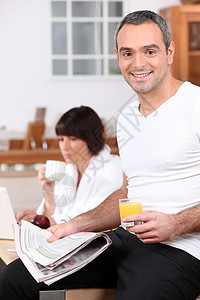 夫妇吃早餐工作玻璃丈夫男人橙子电脑厨房杯子家庭裤子图片