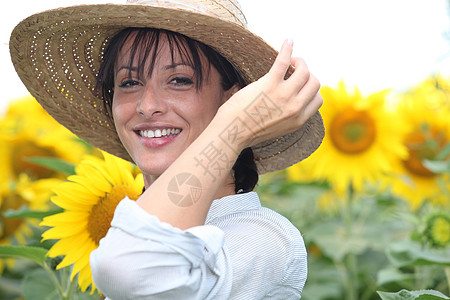 在向日葵田的草帽女人女性微笑叶子植物稻草成人女士花朵农业幸福图片