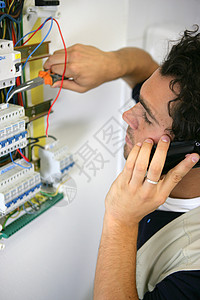 修理电线在引信板上工作的电工背景