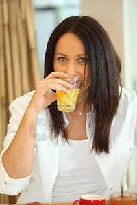 女人在早餐时喝橙汁福利就寝卧室美丽假期食物微笑服务享受时间图片