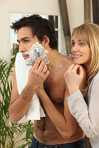 年轻男人和女朋友一起刮胡子 看高清图片