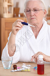 带温度计的老年妇女呼吸温度疾病药品女士治疗桌子阅读卫生痛苦图片