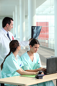 医生看X光电脑专业人员护士女性诊所电话笔记本放射科桌子专家图片