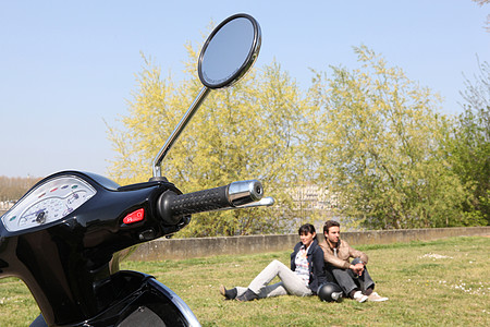 一对夫妇坐在摩托车附近图片