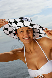 在海滩上戴帽子和比基尼的女人图片