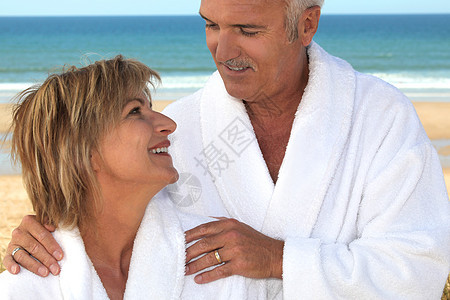 在海滩上穿浴袍的情侣图片