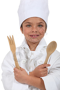 身着厨服 手持木勺子和叉子的十几岁少女图片