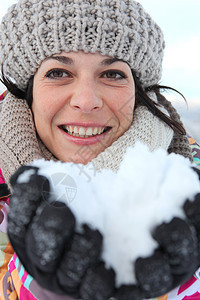 女人在滑雪度假胜地都笑着 手拿着雪雪图片