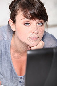 一位年轻女士在她的笔记本电脑前图片