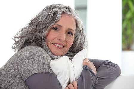 灰色头发的女士拿着坐垫图片