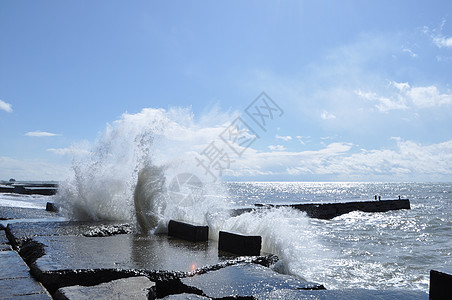 混凝土港口的海浪破浪海洋岩石气泡冲浪天线泡沫痕迹波纹阳光蓝色图片