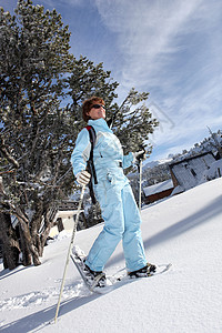 白色衣服素材女性滑雪者在雪中行走的全长镜头背景