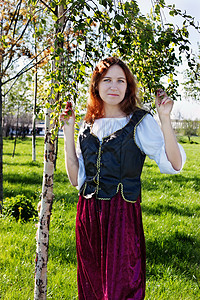 中世纪女人靠近小树枝筋膜衣服头发木头传奇小精灵裙子女孩女士照片图片