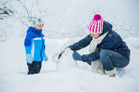 冬季男孩与母亲一起扔雪球图片