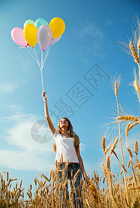 在小麦田配气球的少女享受天空青少年女性自由乐趣喜悦快乐小麦童年图片