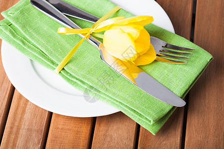 以黄色和绿色方式服务用餐盘子假期桌子花朵桌布午餐派对环境食物图片