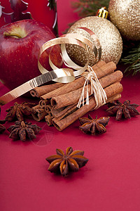 圣诞苹果圣诞装饰红苹果 肉桂 香肠和红底树八角宏观火花香气芳香香料食物丝带假期装饰品背景