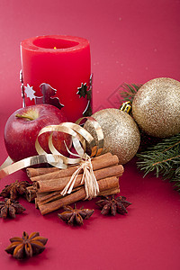圣诞装饰红苹果 肉桂 香肠和红底树八角丝带庆典季节金子香气芳香火花香料蜡烛图片