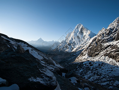 在喜马拉雅山的清晨 乔拉过道和下雪高峰远足高度登山蓝色岩石冒险首脑昆布顶峰大雪图片