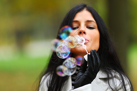 秋天女人吹泡泡青少年头发休息蓝色空气气泡公园草地假期肥皂泡图片