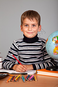 可爱的男生在写字手臂学生教科书班级教育写作小学生铅笔孩子童年图片