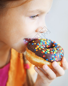 甜甜圈享受食物早餐童年女性乐趣育肥孩子垃圾面团背景图片