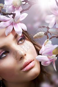 美丽女孩的鲜花脸兰花化妆品头发温泉太阳黑发女士花朵女性护理图片