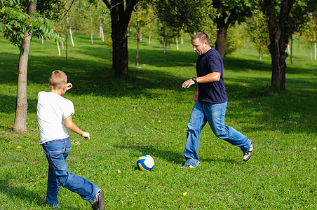 年轻男孩和父亲打橄榄球竞赛运动男性喜悦场地青年童年游戏快乐孩子图片