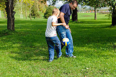 年轻男孩和父亲打橄榄球训练儿子运动男生游戏竞赛家庭微笑乐趣孩子图片
