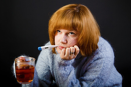 带茶和温度计的生病女孩图片