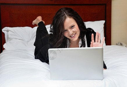 商业女商务人士躺在床上用笔记本电脑人士工作旅馆酒店说谎旅行管理人员成人微笑女孩图片