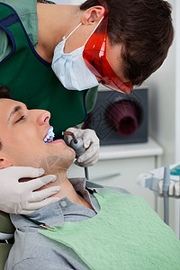 在牙科诊所做牙牙牙工作的牙医图片
