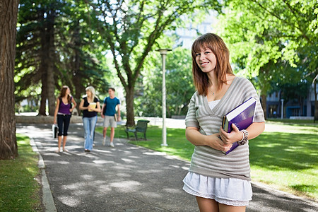 女大学生拿着一本书站着图片