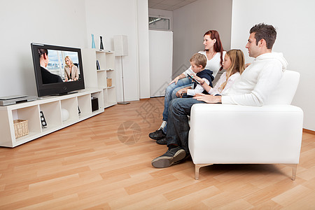 年轻家庭在家看电视女士微笑程序男生女孩男人妈妈爸爸孩子姐姐图片