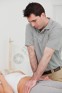 严重理疗师操纵病人骨盆的重度物理治疗师图片