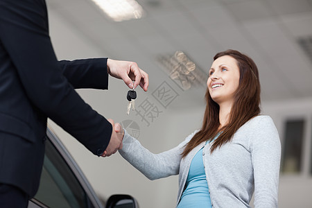 客户在握手时收到汽车钥匙人士汽车会议女士套装快乐车库棕色商务经销商图片