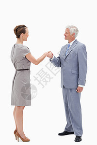 白发商务人士面对面笑和握手的白发商务人士图片