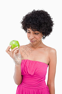 年轻姑娘看着她美味的绿苹果图片