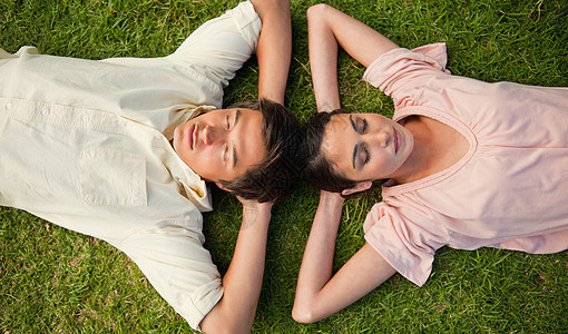 两个朋友躺在头顶 双手在脖子后面躺着头顶友谊喜悦情人公园幸福休息年轻人女性说谎手臂图片