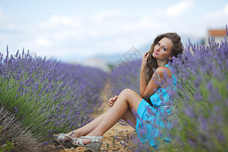 女人坐在紫衣草地上幸福女孩爬坡黑发紫色享受活动土地快乐微笑图片