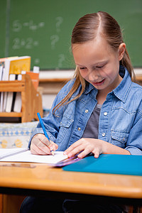 女学生写作的肖像桌子学生小学生学校作业铅笔黑板童年家庭教育图片