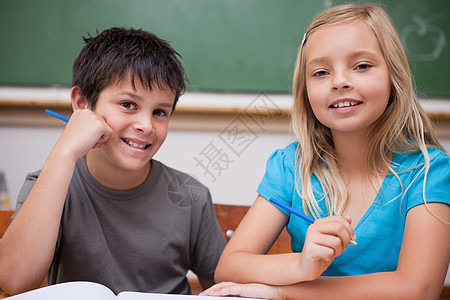 微笑的学生们一起工作家庭作业小学生阅读班级两个人伴侣瞳孔教育桌子朋友们图片