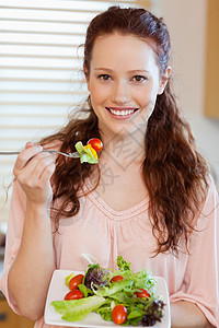 女孩吃沙拉女士厨房饮食美食食物房子快乐绿色午餐微笑图片