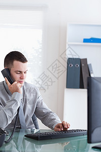商界人士聆听来电者职业电话电脑外表公司工作商务办公室经理职场背景图片
