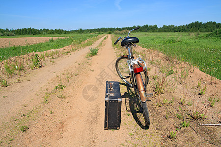 农村公路上旧自行车附近的旧车价图片