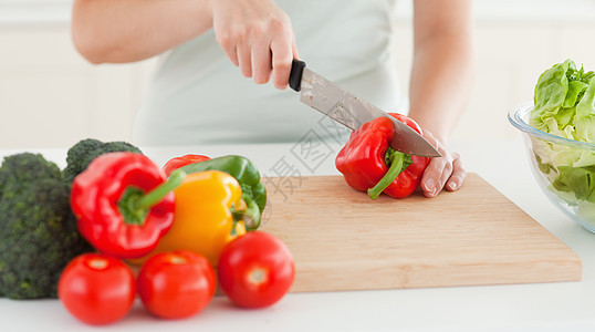 妇女切割蔬菜食物营养桌子胡椒沙拉木头女性美食手指午餐图片